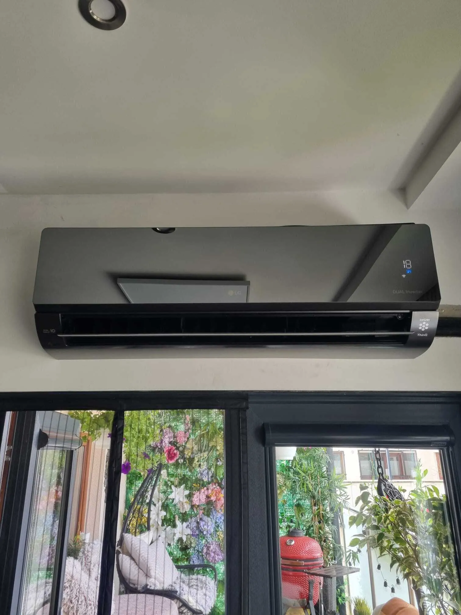 Black wall-mounted air conditioner above a patio door