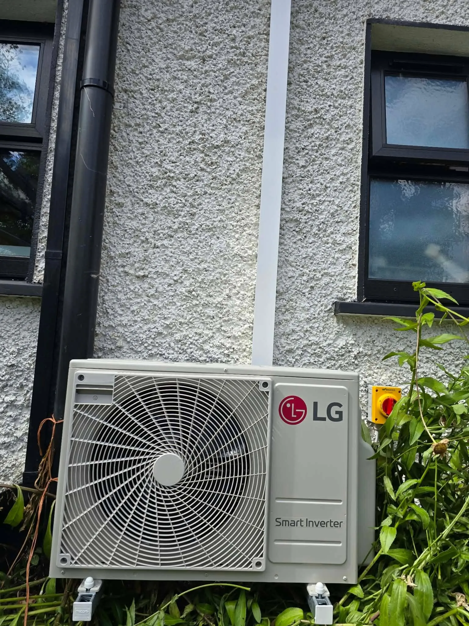 LG outdoor unit on a pebble-dash house wall