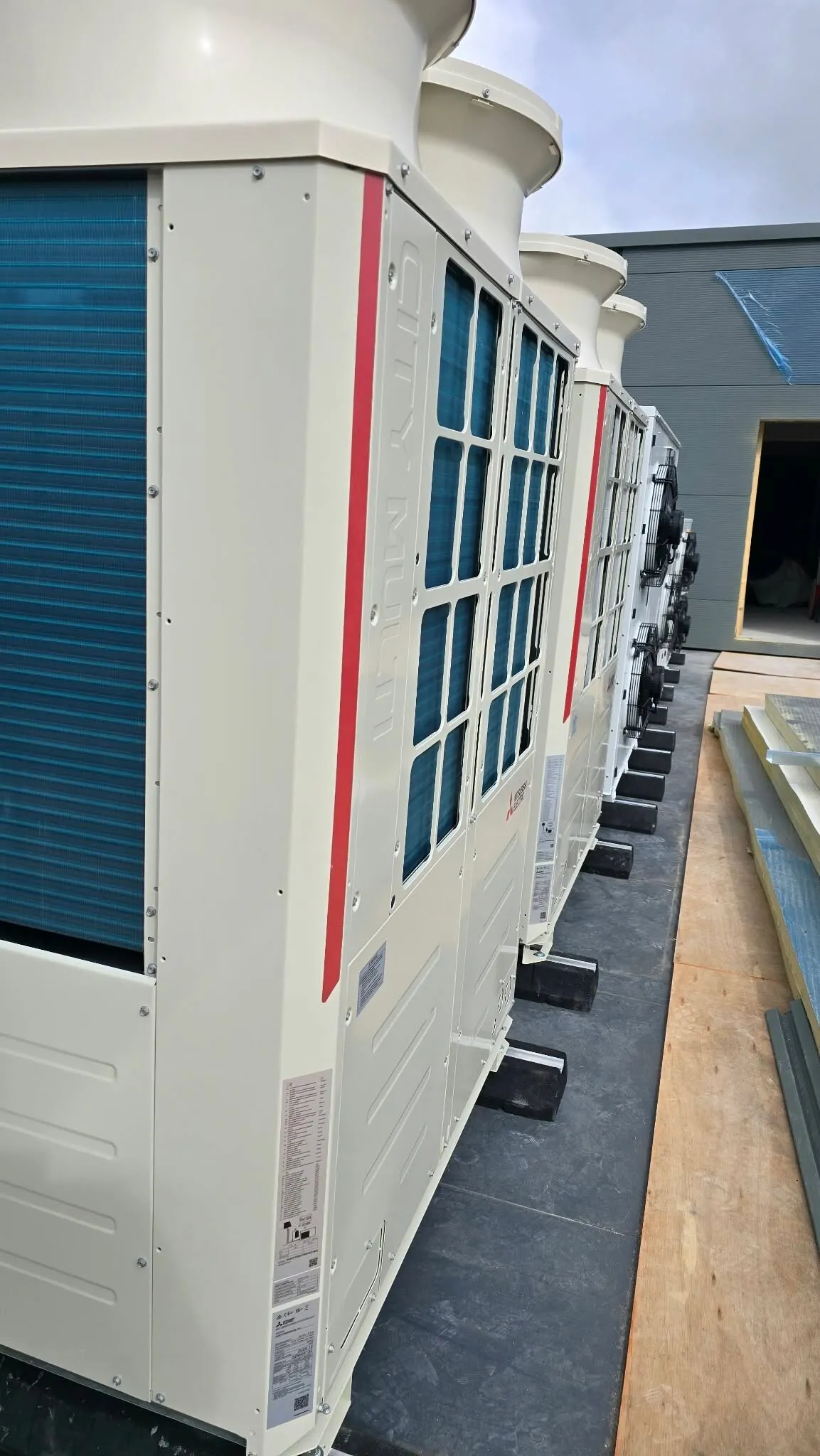 Row of Mitsubishi VRF outdoor units, side view