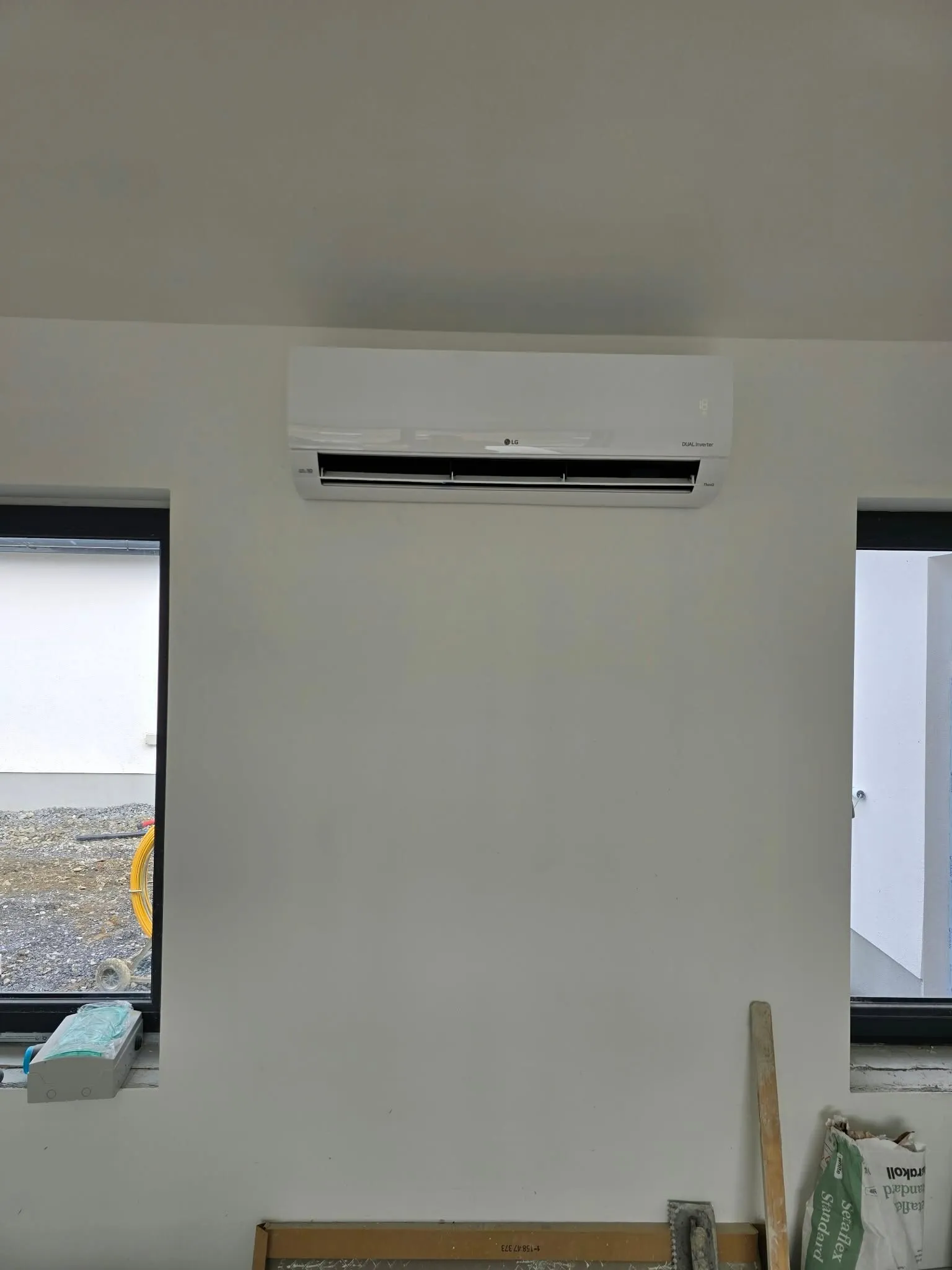 Wall-mounted air conditioner between two windows